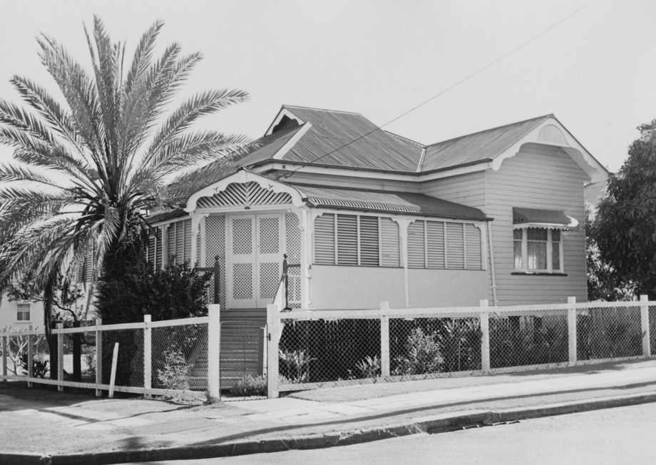A picture of a house with a fence and a palm tree out the front at Stone's Corner
