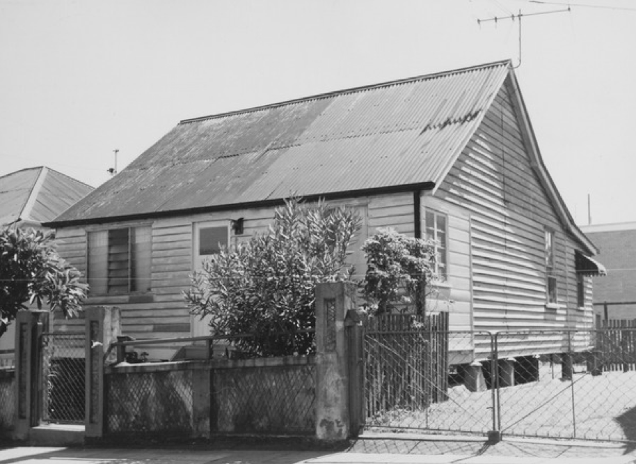 A picture  of an old house with shrubs in front of it in Woolloongabba